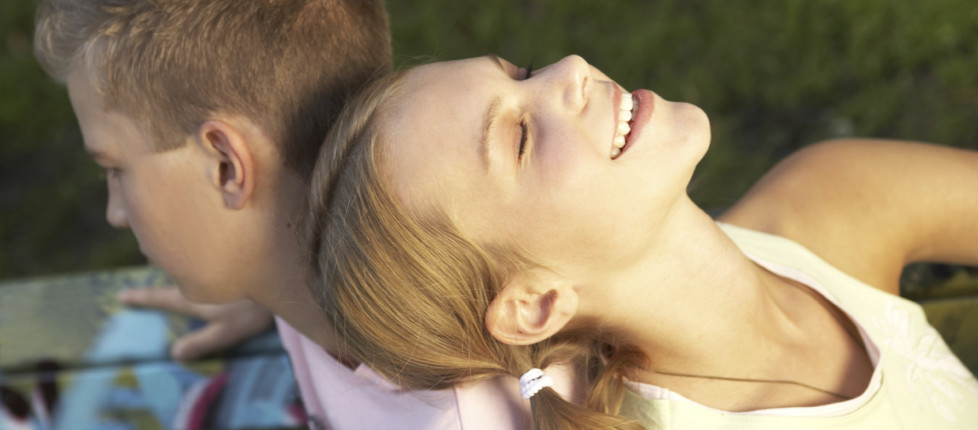 A young couple sitting on a bench.